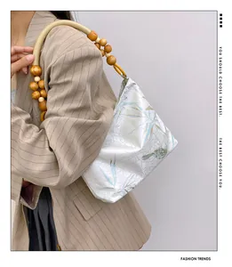 Dettaglio di borsa floreale in stile New Chinese con manico in perline di legno.