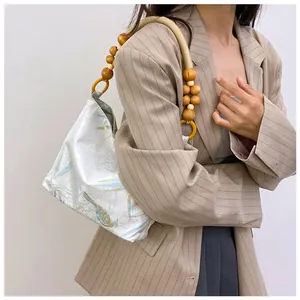 Dettaglio di borsa a mano vintage stampata con manico di perle su modella