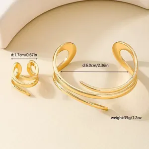 Vista dettagliata del set di anello e bracciale dorati a più strati con dimensioni