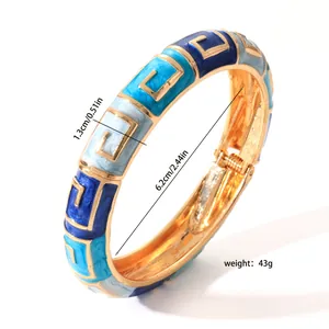 Detailansicht eines eleganten blauen Emaille-Armreifs mit geometrischem Goldmuster im Retro-Look