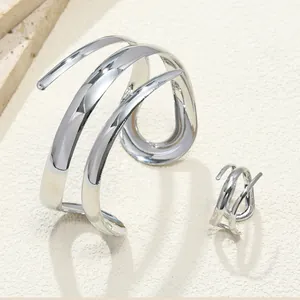 Dettaglio del bracciale rigido in metallo traforato a tre strati e dell'anello coordinato.