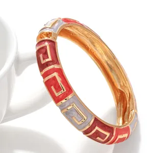 Nahaufnahme eines geometrischen Emaille-Armreifs mit roten und weißen Mustern