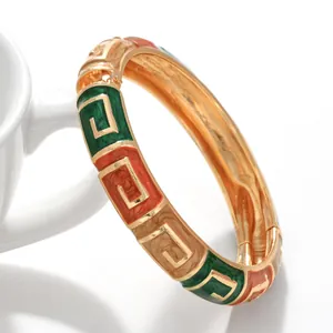 Detailansicht eines Vintage-Emaille-Armreifs mit grünem und orangefarbenem Muster