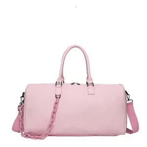 Detail of pink crocodile texture travel bag with shoulder strap and chain