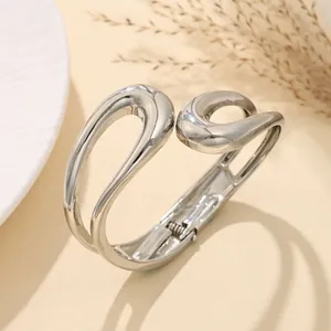 Dettaglio della finitura lucida di un bracciale a onde minimalista in metallo argento