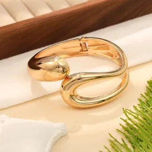 Vista dettagliata della finitura a specchio lucida e del design a onde irregolari di questo bracciale.
