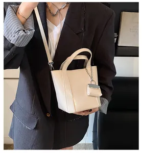 Detailaufnahme einer cremefarbenen minimalistischen Beuteltasche mit Blazer.