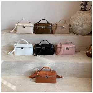 Detailed view of seven colors of crocodile pattern box handbags on stone stairs