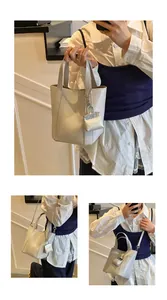 Cremefarbene minimalistische Beuteltasche aus weichem Leder mit Mini-Anhänger-Detail