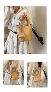 Detailaufnahmen einer gelben Retro-Beuteltasche, die als Schulter- und Handtasche dient