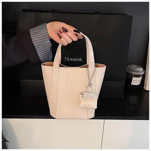 Detailansicht einer cremefarbenen, weichen Leder-Eimertasche mit kleinem Anhänger