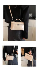Close-up detail of beige crocodile embossed box bag featuring silver hardware zipper