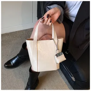 Detailansicht einer beige minimalistischen Beuteltasche mit kleiner dekorativer Kettentasche