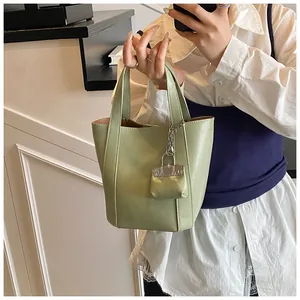 Nahaufnahme eines minimalistischen hellgrünen Beutel-Shoppers mit süßem Mini-Anhänger.