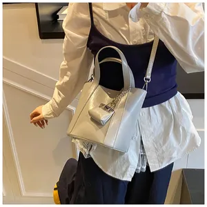 Eleganter grauer Eimerbeutel aus Kunstleder am Model mit stilvollem Ketten-Detail