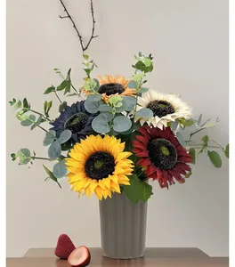 Detailansicht gemischter künstlicher Sonnenblumen und Eukalyptus in grauer Vase