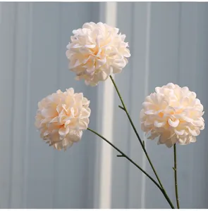 Nahaufnahme von drei cremefarbenen künstlichen Ball-Chrysanthemen mit realistischen Stielen.