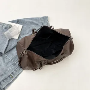 Detailed interior view of a brown crocodile embossed travel bag with black lining.