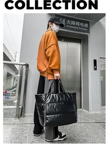 Bolso de viaje acolchado negro de gran capacidad llevado por un modelo en zona urbana.
