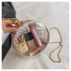 Detailed view of a unique transparent round crossbody bag featuring gold chain strap