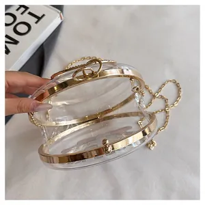 Detailed interior view of a transparent round acrylic crossbody bag with gold chain