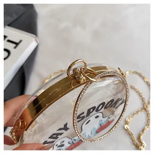 Close-up of a transparent round clutch with a ghost print and gold chain strap