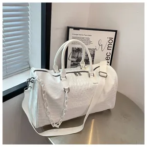 Close-up of white crocodile pattern travel bag with detachable wide shoulder strap