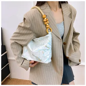 Vista dettagliata di una modella con borsa vintage in stile cinese e tracolla con perline