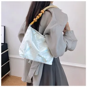 Dettaglio di una borsa hobo in stile cinese con stampa di uccelli e perline di legno