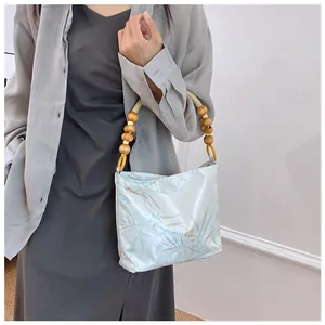 Dettaglio della borsa floreale retrò con manico in perline di legno unico per l'eleganza