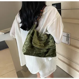 Detalle de bolso de hombro de terciopelo verde con correa de cuentas estilo neo-chino