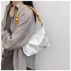 Dettaglio di una borsa a mano vintage in stile New Chinese con stampa uccelli e perline.