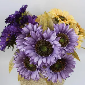 Detailed macro view of artificial sunflower bouquet in purple and yellow silk fabric.
