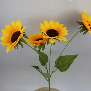 Detailed view of bright yellow simulation sunflower heads with realistic green leaves