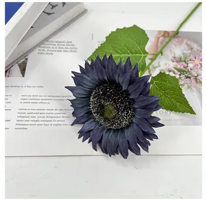 Detailansicht einer marineblauen künstlichen Sonnenblume mit zwei grünen Blättern