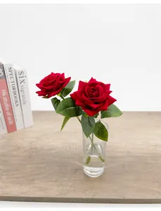 Vista dettagliata dei petali di rosa rossa artificiale in velluto in un vaso di vetro