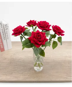 Dettaglio di eleganti rose rosse di velluto artificiale in un vaso di vetro trasparente