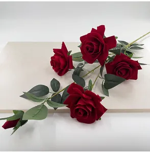 Detail view of 5-head red velvet artificial roses with realistic green leaves decoration