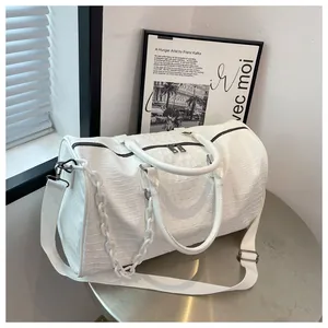 Close-up side view showing crocodile texture and chain of white large travel bag