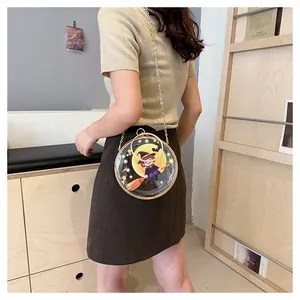 Model carrying a transparent round crossbody bag with a cute Halloween witch design