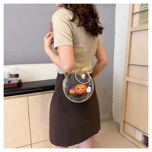 Unique circular transparent Halloween crossbody bag with pumpkin print shown on model