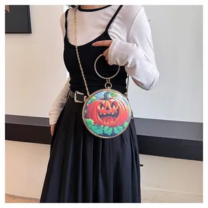 Detail of round Halloween pumpkin handbag with sparkly crystal handle and chain strap
