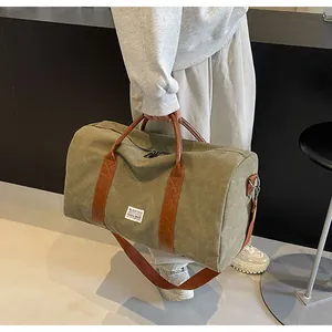 Robuste Reisetasche aus olivgrünem Canvas mit braunen Riemen für kurze Ausflüge.