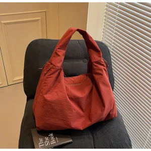 Detalle de un bolso de hombro de nailon terracota de gran capacidad para mujer