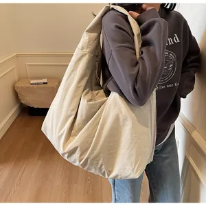 Un bolso hobo minimalista beige de gran capacidad mostrado en un ambiente casual