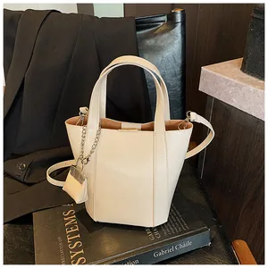 Detailansicht der cremefarbenen Bucket Bag mit eleganter dekorativer Kettenverzierung