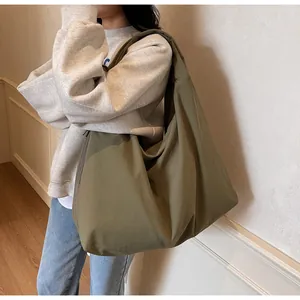 Bolso hobo verde oliva de gran capacidad llevado por una modelo en un ambiente casual