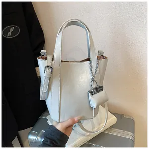 Detailansicht einer grauen minimalistischen Beuteltasche mit kleinem Beutel-Anhänger