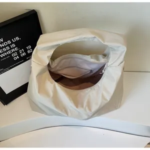 Vista detallada del compartimento interior con cremallera de un bolso hobo beige grande
