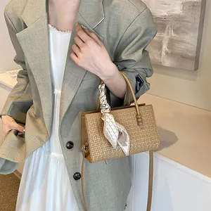Elegante beige geweven handtas voor dames met een modieuze zijden sjaal met print